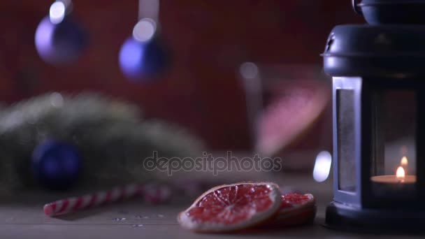 Kokteyl greyfurt, mum, köknar dalı ile Noel oyuncaklar ve şekerler kırmızı tuğla üzerinde — Stok video