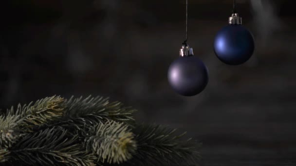 Zwei blaue Weihnachtskugeln und Fichtenzweige auf dem Hintergrund des schönen Bokeh. — Stockvideo