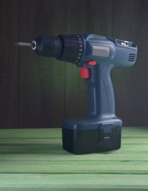 Ahşap bir masa üzerinde koyu mavi matkap.