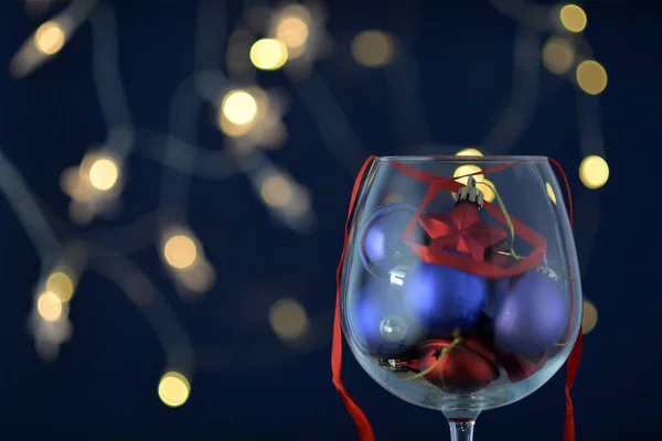 Bokeh arka plan üzerinde Noel oyuncaklar ile şarap cam cam.