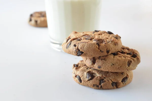 Biscuits with chocolate chips inside and a glass of milk. — Stock Photo, Image