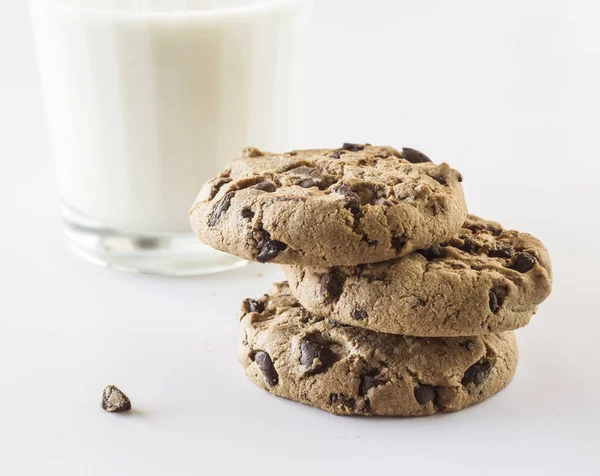 Biscuits with chocolate chips inside and a glass of milk. — Stock Photo, Image