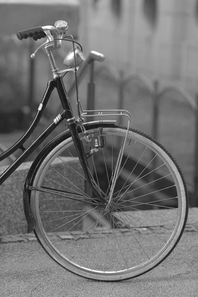 Bulanık şehir arka plan üzerinde beyaz tekerlekli siyah Bisiklet. — Stok fotoğraf