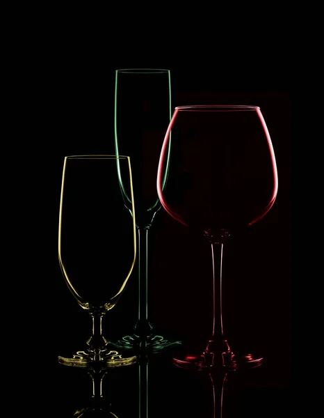 Copos transparentes coloridos para vinho em um fundo preto . — Fotografia de Stock