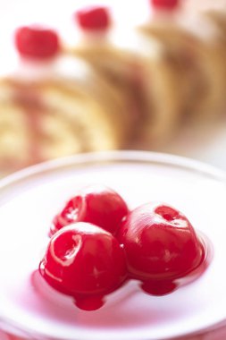 Kek krem ve hafif bir arka plan üzerinde kiraz.