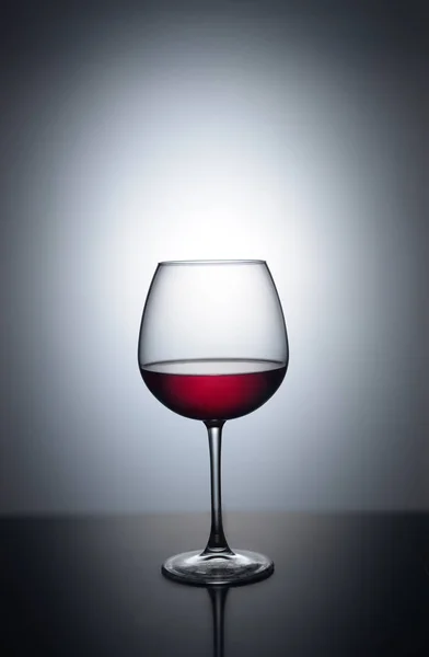 Spritzer Rotwein in einem Glas auf weißem Hintergrund mit Spiegelung — Stockfoto