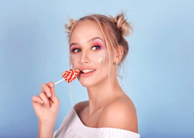 Mavi bir arka planda çok tatlı ve güzel bir kız. Parlak makyajlı. Tatlıları, kekleri, çörekleri ve kurabiyeleri seviyor. Hanımefendi gülümsüyor ve hayattan zevk alıyor. Parlak ve lezzetli.