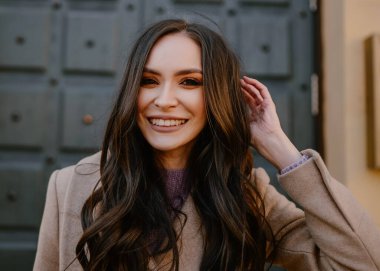 Gülücükler saçan güzel bir kız, gülen çiçeklerle, güneşli havada sokakta portre, lalelerle mutlu kahve içmek, kahkahalar atan bir kitap okumak, bahar mevsiminde makyajlı, ince bir palto giymiş, şık bir mankenle.