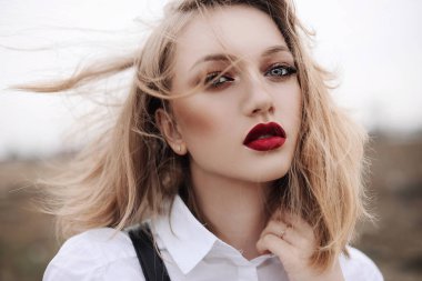 Kız sokakta yürüyor, bahar ve harika hava, parlak makyaj, şapka, büyük mavi gözler, kar yağıyor, kış, soğuk, kırmızı dudaklar, kızarma, genç kız