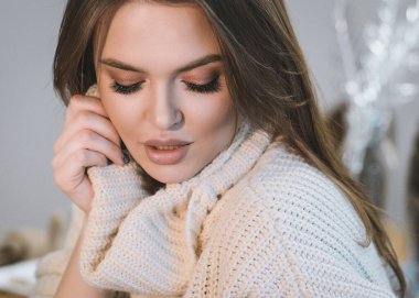 Güzel bir genç kız evde küçük tüylü Samoyed Husky köpekleriyle oynuyor. Mutfakta, yatakta ve Noel ağacının yanında bulunur. Noel için her şey dekore edildi. Kız köpeklerin yanında gülüyor! yakında yeni yıl