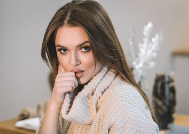 Güzel bir genç kız evde küçük tüylü Samoyed Husky köpekleriyle oynuyor. Mutfakta, yatakta ve Noel ağacının yanında bulunur. Noel için her şey dekore edildi. Kız köpeklerin yanında gülüyor! yakında yeni yıl