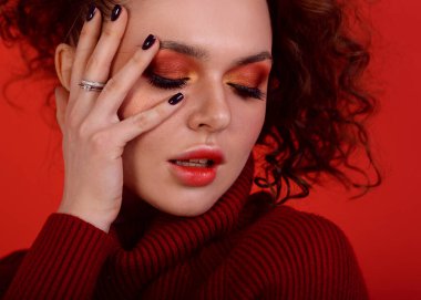 Kırmızı elbiseli güzel bir kız ve parlak kırmızı Smokey makyajlı ve bulanık oklu ben. Kırmızı arka planda bir portre, tamamen kırmızı, gülen ve eğlenen bir kız, Afro kıvırcık saçları ve harika bir atletik figürü var.