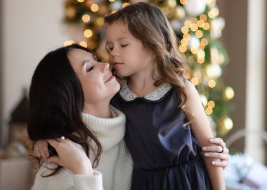 Anne ve kızı Noel ağacında eğleniyorlar, mutlular, gülüyorlar. Yeni yıla makyajlı ve saç stiliyle gireceğiz. Mutlu ve güzel hediyelerle Noel Baba 'yı bekliyor.