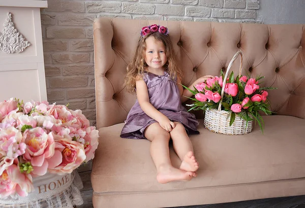 Çiçeklerle Lalelerle Çevrili Şapkalı Narin Elbiseli Küçük Tatlı Bir Kız — Stok fotoğraf