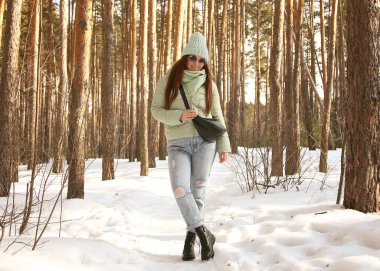 Güzel bir kız Rus çam ormanlarında yürüyor.