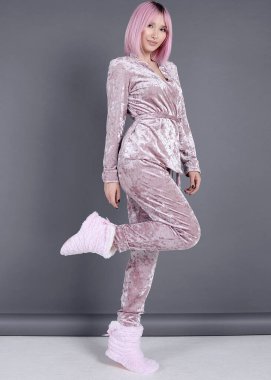 İpek ve kadife pijama ve ev kostümü içinde renkli arka planda güzel bir kız.