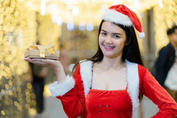 아시아 여성의 초상화에는 아름다운 보케등을 배경으로 크리스마스 선물로 산타클로스 복장을 — 스톡 사진