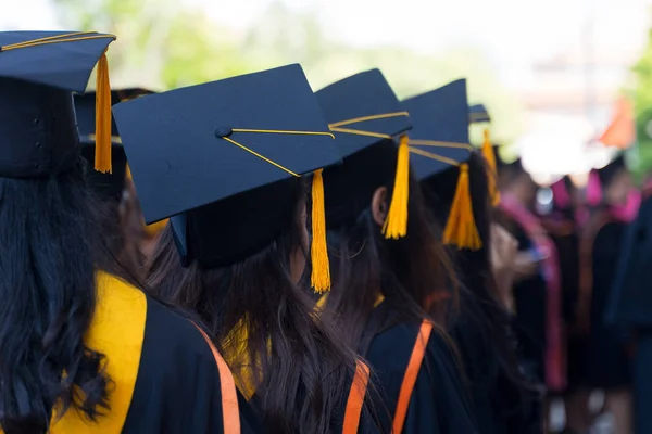 Visão traseira e foco seletivo suave dos graduados na cerimônia de início da graduação que recebe um certificado de diploma . — Fotografia de Stock