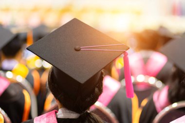 Mezuniyet törenindeki mezunların diploma sertifikası alırken dikkatli ve seçici bakışları..