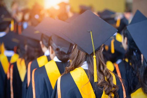 Soft selective focus rear view of the graduates in the graduation commencement ceremony receiving diploma degree certificate. — Stock Photo, Image