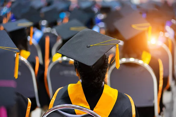 Soft selective focus rear view of the graduates in the graduation commencement ceremony receiving diploma degree certificate. — Stock Photo, Image