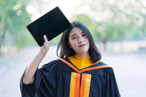 Jovem Alegre Bonito Gradute Feminino Vestindo Vestido Acadêmico Segurando Tablet — Fotografia de Stock