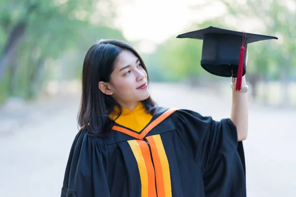 Retrato Jovem Graduado Feminino Alegre Vestindo Vestido Acadêmico Segurando Tampa — Fotografia de Stock