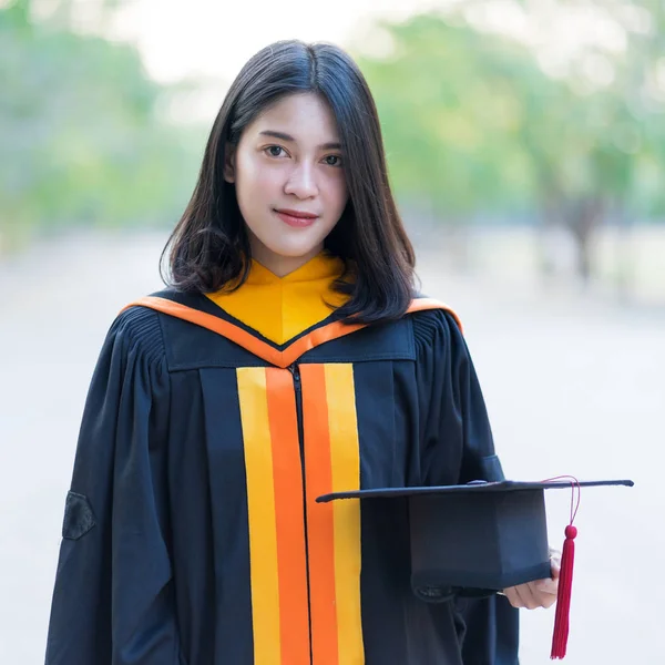 Close Retrato Uma Jovem Alegre Graduada Vestindo Vestido Acadêmico Segurando — Fotografia de Stock