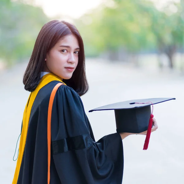 Close Retrato Uma Jovem Alegre Graduada Vestindo Vestido Acadêmico Segurando — Fotografia de Stock