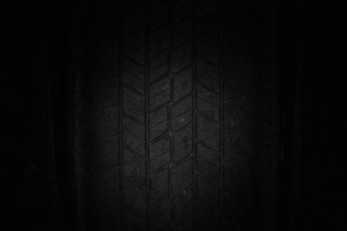 Araba lastikleri üst üste bir raf üzerinde lastik. Karanlıkta yakın çekim.