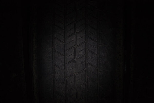 Car tires in a row on a shelf tire. Close-up in dark.
