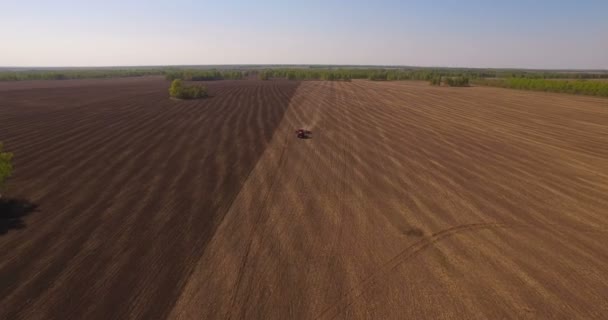 収穫現場におけるトラクターの空中 — ストック動画