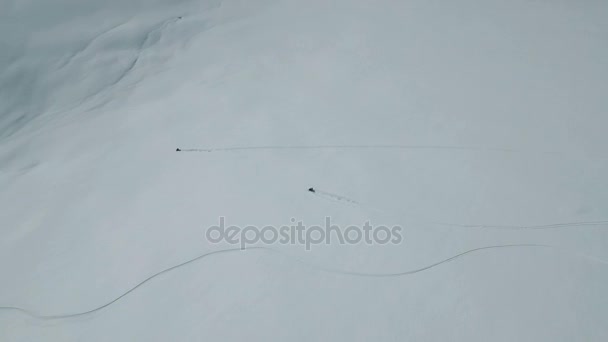 Snöskotrar avgifter ner ett berg i pudersnö — Stockvideo