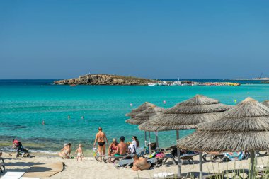 Turistler ünlü Kıbrıs plajında dinleniyorlar. Nissi Plajı