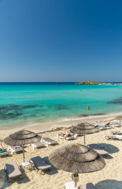 Turistler ünlü Kıbrıs plajında dinleniyorlar. Nissi Plajı