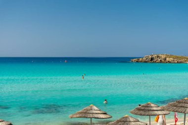 Turistler ünlü Kıbrıs plajında dinleniyorlar. Nissi Plajı