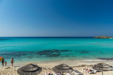 Turistler ünlü Kıbrıs plajında dinleniyorlar. Nissi Plajı