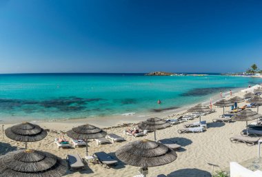 Turistler ünlü Kıbrıs plajında dinleniyorlar. Nissi Plajı