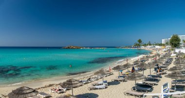 Turistler ünlü Kıbrıs plajında dinleniyorlar. Nissi Plajı