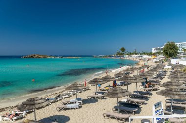 Turistler ünlü Kıbrıs plajında dinleniyorlar. Nissi Plajı