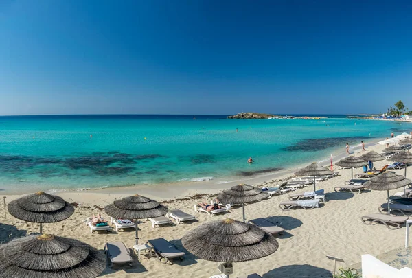 Turistler ünlü Kıbrıs plajında dinleniyorlar. Nissi Plajı