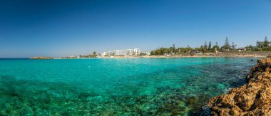 CYPRUS, NISSI BEACH - MAY 12/2018: Tourists relax and swim on one of the most popular beaches on the island.