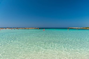 CYPRUS, NISSI BEACH - MAY 12/2018: Tourists relax and swim on one of the most popular beaches on the island.