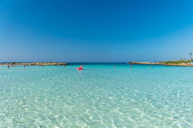 CYPRUS, NISSI BEACH - MAY 12/2018: Tourists relax and swim on one of the most popular beaches on the island.