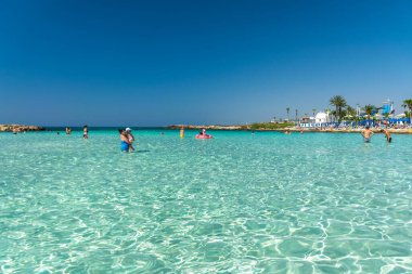 CYPRUS, NISSI BEACH - MAY 12/2018: Tourists relax and swim on one of the most popular beaches on the island.