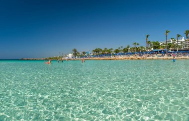 CYPRUS, NISSI BEACH - MAY 12/2018: Tourists relax and swim on one of the most popular beaches on the island.