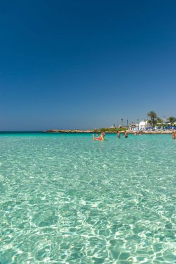 CYPRUS, NISSI BEACH - MAY 12/2018: Tourists relax and swim on one of the most popular beaches on the island.