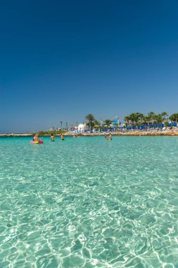 CYPRUS, NISSI BEACH - MAY 12/2018: Tourists relax and swim on one of the most popular beaches on the island.