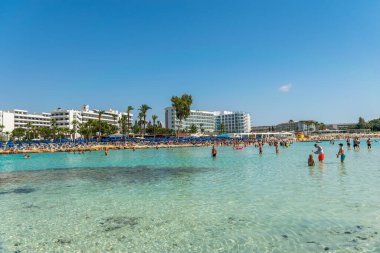 CYPRUS, NISSI BEACH - MAY 12/2018: Tourists relax and swim on one of the most popular beaches on the island.