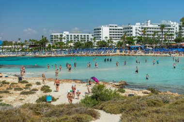 CYPRUS, NISSI BEACH - MAY 12/2018: Tourists relax and swim on one of the most popular beaches on the island.